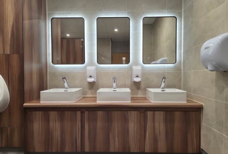Back lit mirrors on vanity unit for commercial washroom